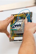 Electrician man installing electric fuse at home.